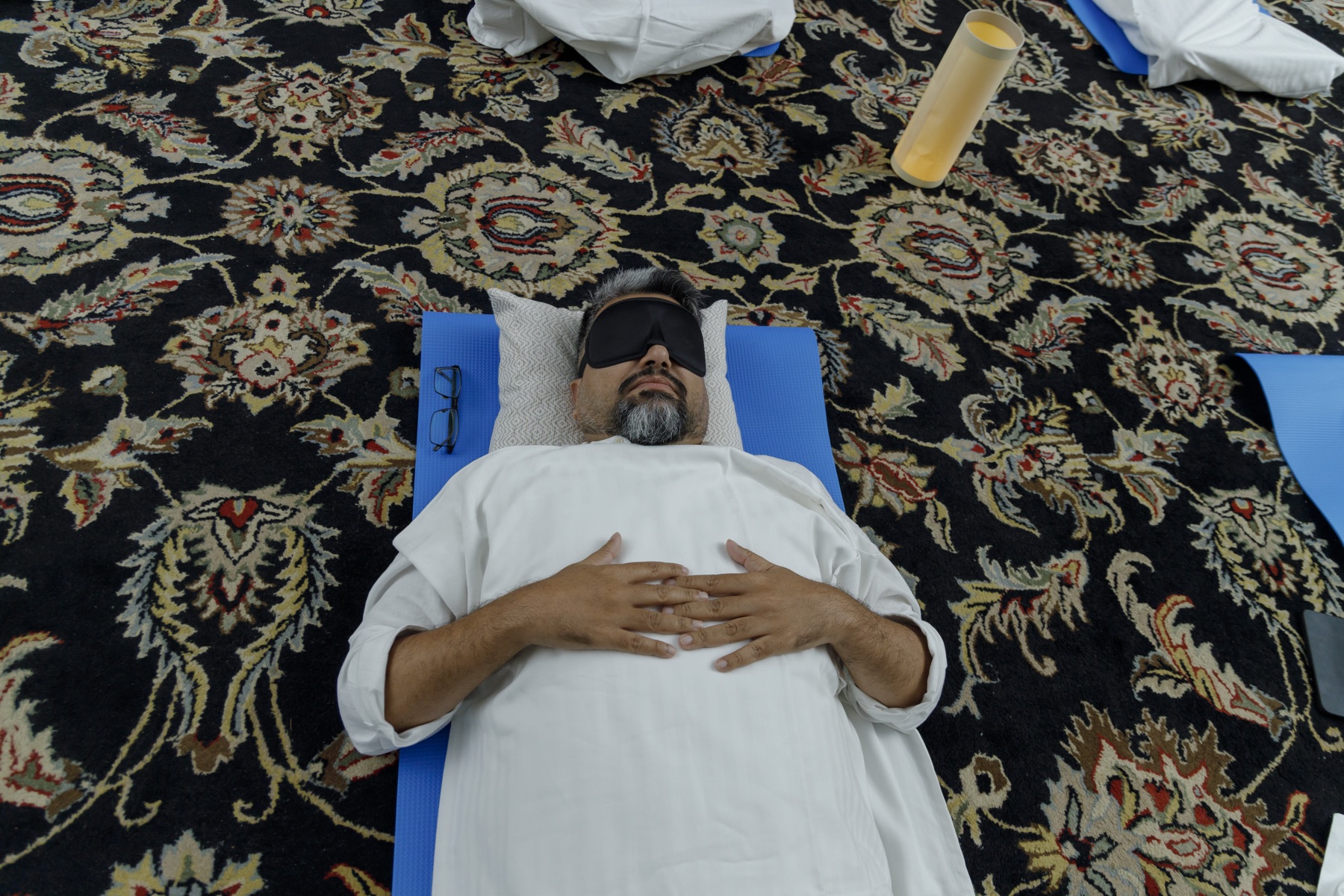 A solitary breathwork journey, eyes covered, hands resting on the chest