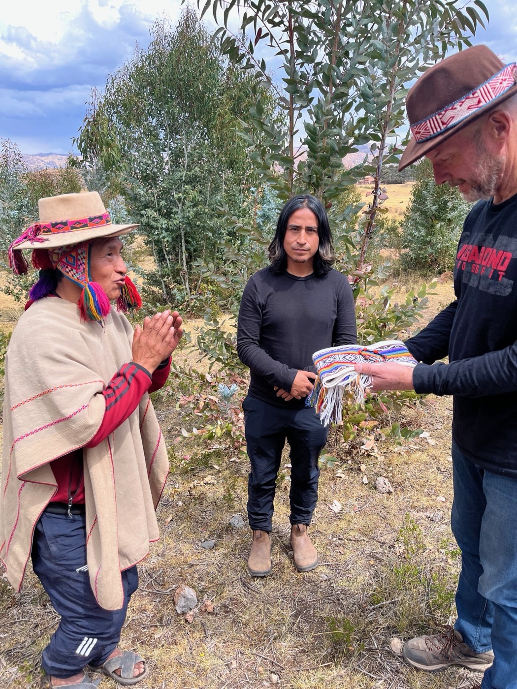 Mark Worster receiving a woven mesa cloth from a Q'ero paqo in the Andes